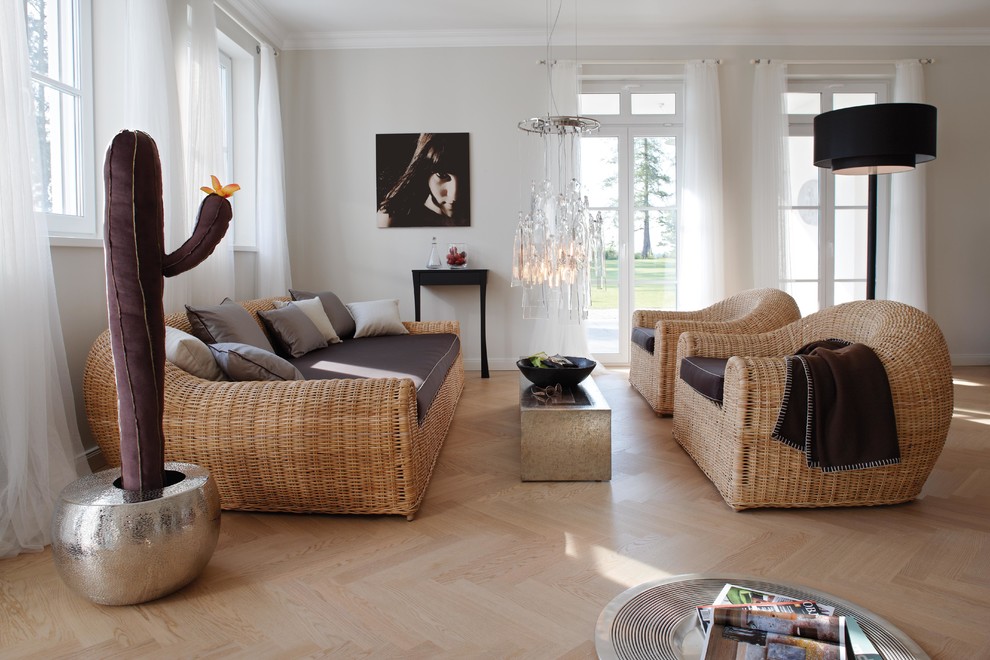 Immagine di un soggiorno design aperto e di medie dimensioni con sala formale, pareti grigie e parquet chiaro