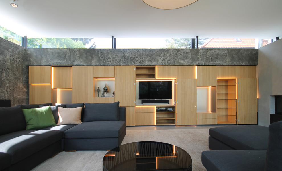 Exemple d'une grande salle de séjour tendance ouverte avec un mur gris, sol en béton ciré, une cheminée standard, un manteau de cheminée en béton, un téléviseur dissimulé et un sol gris.
