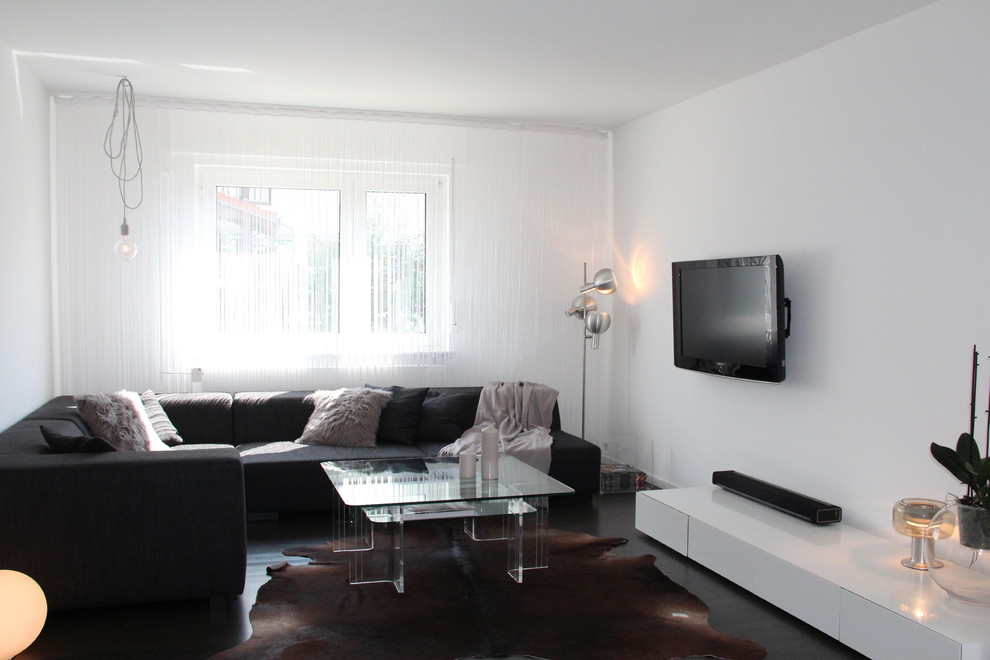 Mittelgroßes, Offenes Modernes Wohnzimmer ohne Kamin mit weißer Wandfarbe, dunklem Holzboden und TV-Wand in Bonn