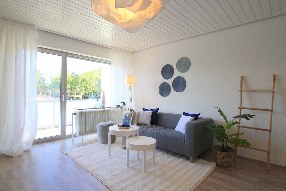 Diseño de salón nórdico con paredes blancas y suelo laminado