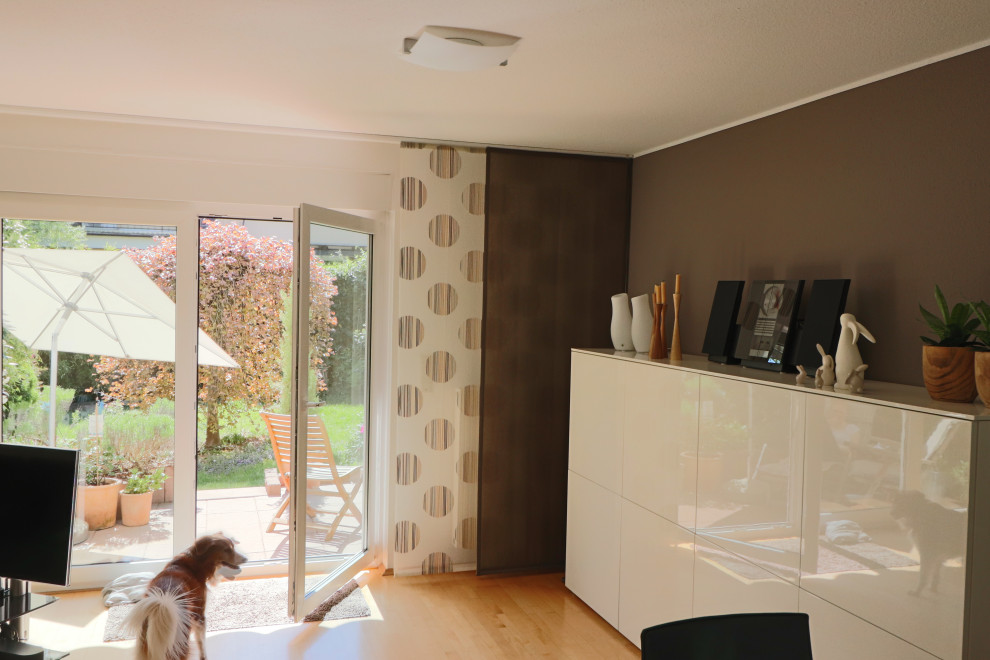 Modelo de sala de estar actual con paredes marrones, suelo de madera en tonos medios, papel pintado y papel pintado