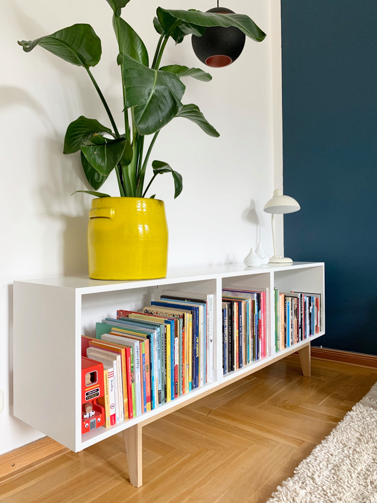 Idee per un grande soggiorno minimal aperto con angolo bar, pareti blu, pavimento in legno massello medio, TV a parete e pavimento marrone