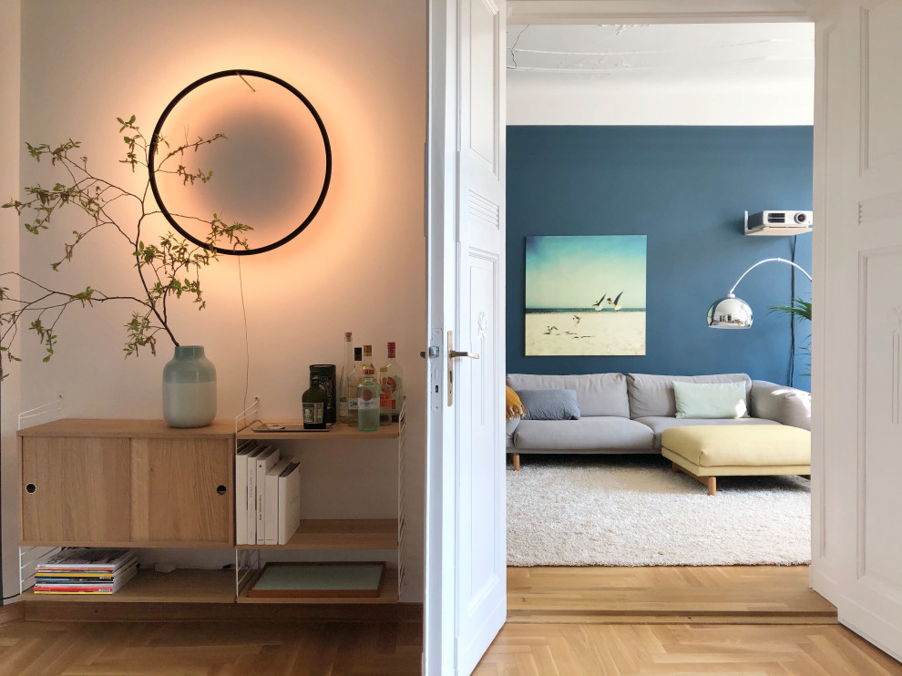 Foto di un grande soggiorno contemporaneo aperto con angolo bar, pareti blu, pavimento in legno massello medio, TV a parete e pavimento marrone