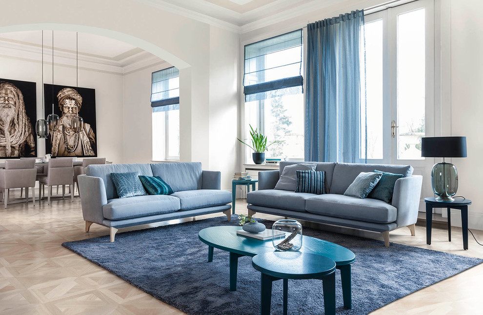 Imagen de sala de estar abierta clásica renovada grande sin chimenea y televisor con paredes blancas y suelo de madera clara