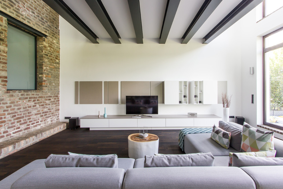 Example of a large urban formal and enclosed dark wood floor and brown floor living room design in Cologne with a tv stand, white walls and no fireplace