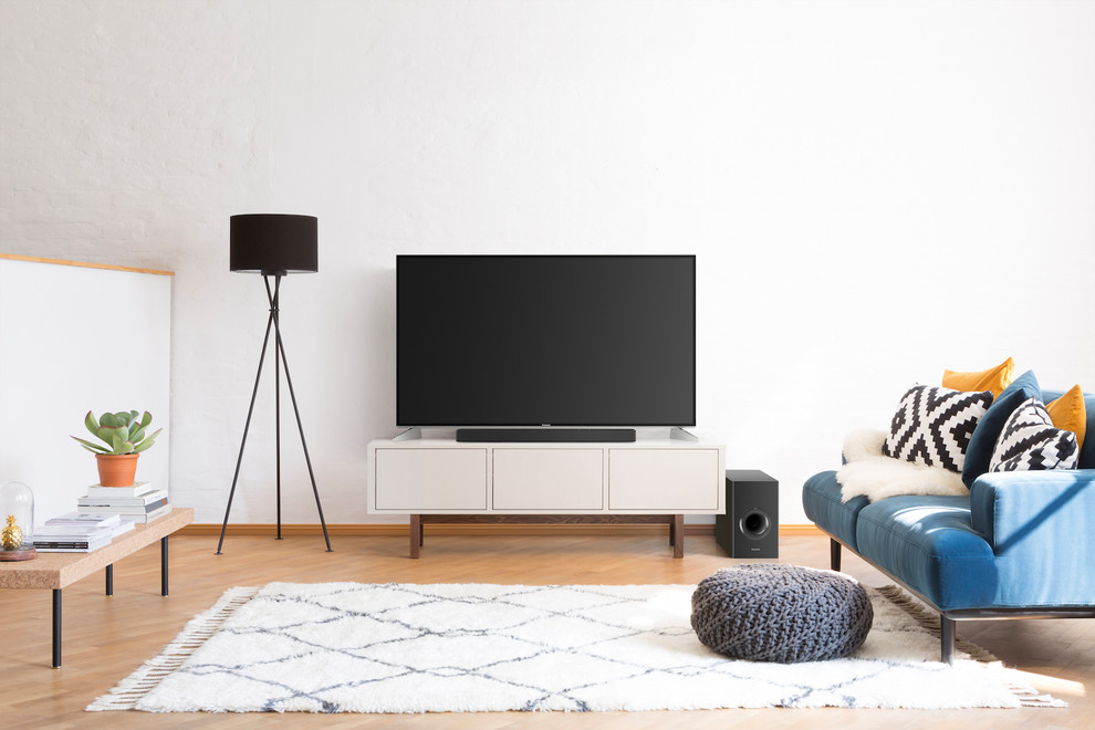 Foto de sala de estar cerrada escandinava de tamaño medio con paredes blancas, suelo de madera en tonos medios, televisor independiente y suelo marrón