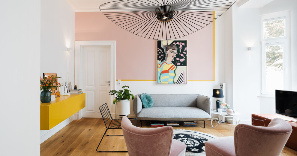 Imagen de sala de estar cerrada bohemia de tamaño medio sin chimenea con paredes blancas, suelo de madera en tonos medios, televisor independiente y suelo marrón