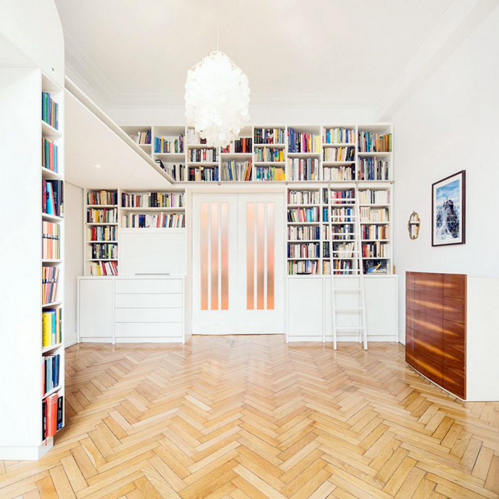 Immagine di un soggiorno contemporaneo chiuso con libreria, pareti bianche, parquet chiaro e nessun camino