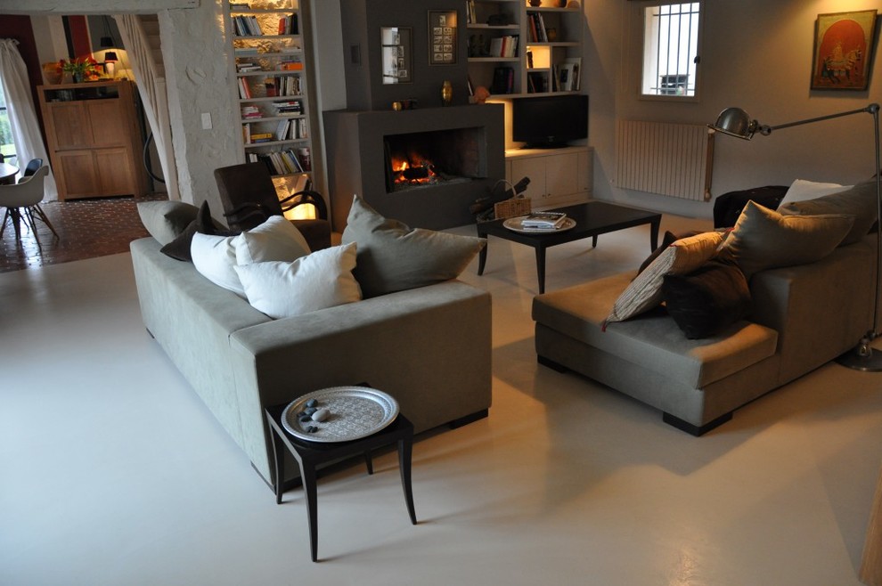 Modelo de sala de estar clásica con chimenea de doble cara, paredes grises, suelo de cemento y marco de chimenea de hormigón