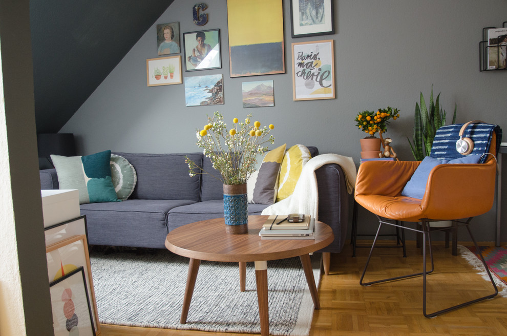 Kleines, Abgetrenntes Modernes Wohnzimmer ohne Kamin mit grauer Wandfarbe und braunem Holzboden in München