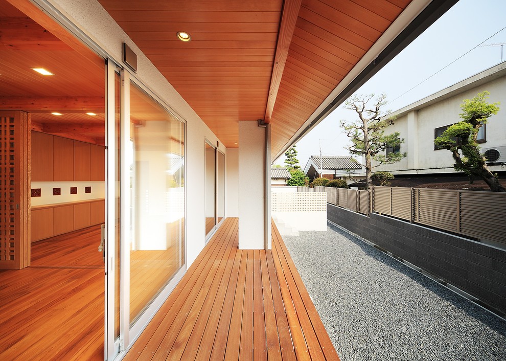 Exemple d'une terrasse latérale asiatique avec une extension de toiture.