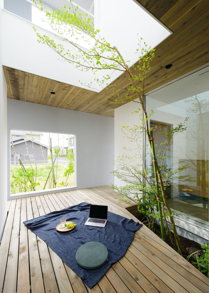 Réalisation d'une terrasse asiatique avec une cour et une extension de toiture.