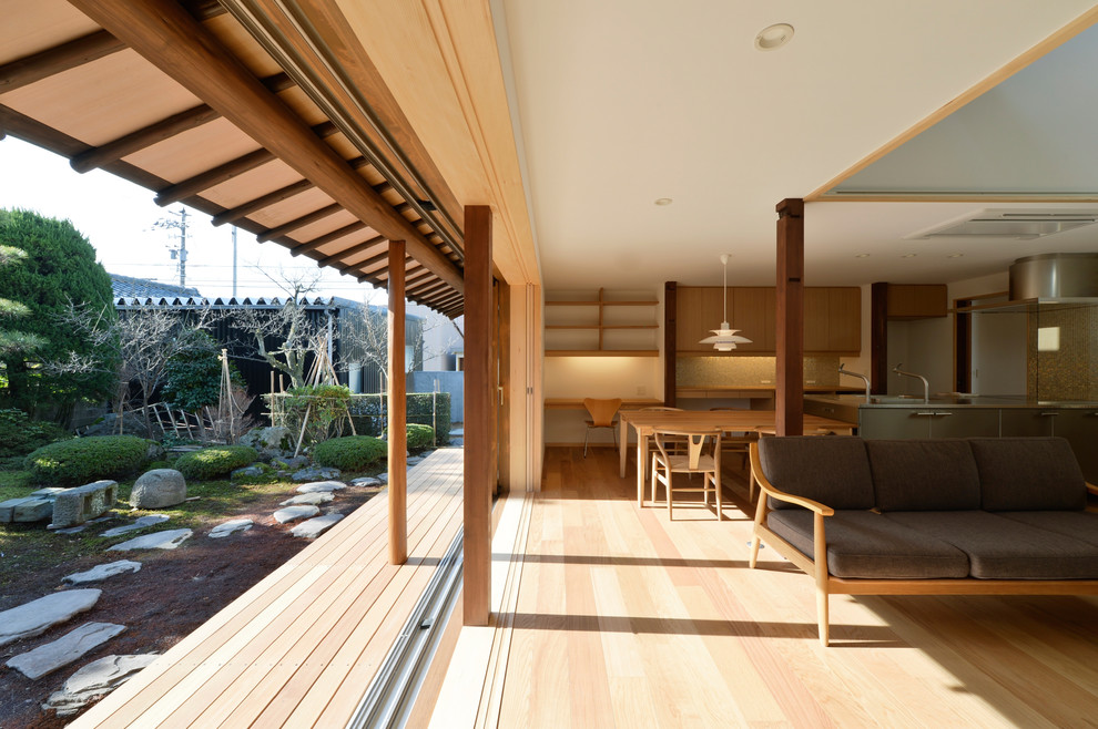 Cette photo montre une terrasse asiatique avec une extension de toiture.