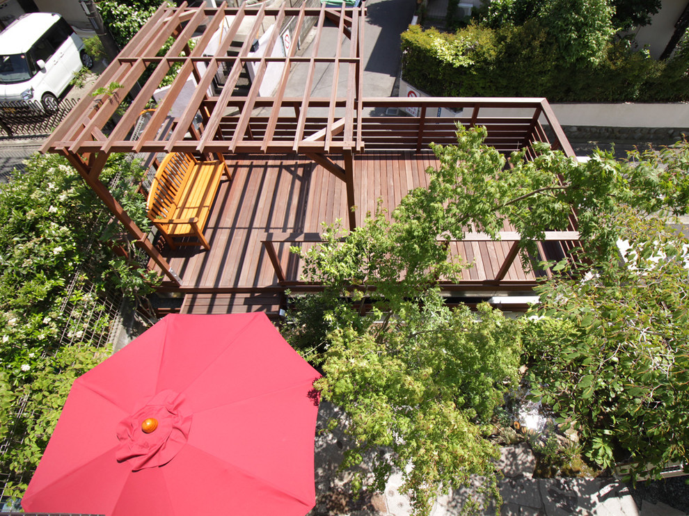 Ejemplo de terraza asiática de tamaño medio en patio trasero con cocina exterior y pérgola