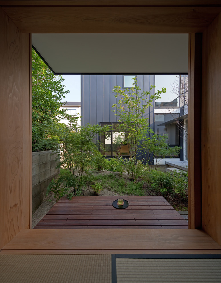 Cette photo montre une terrasse asiatique avec une cour et une extension de toiture.