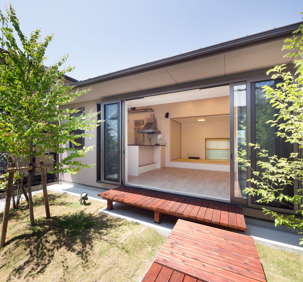 Réalisation d'une petite terrasse arrière asiatique avec une extension de toiture et une cuisine d'été.