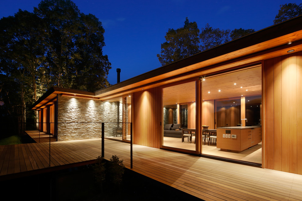 Modelo de terraza minimalista sin cubierta en patio lateral con iluminación