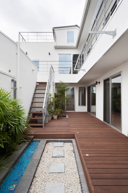 aménagement toit terrasse -canapé-résine-tressée-table-basse-cageot-tapis-extérieur-cuisine-blanche