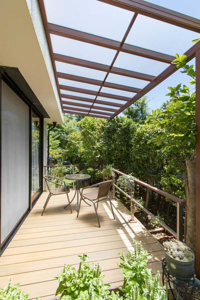 Diseño de terraza moderna en patio lateral con cocina exterior y toldo