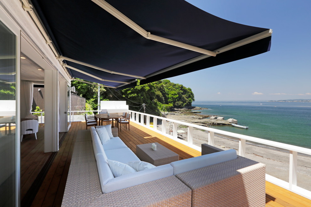 Ispirazione per una terrazza stile marinaro con un parasole