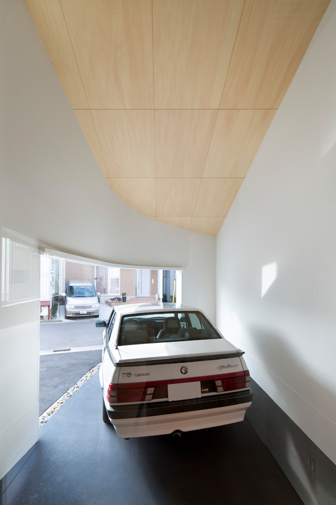 Aménagement d'un garage pour une voiture attenant moderne avec un bureau, studio ou atelier.