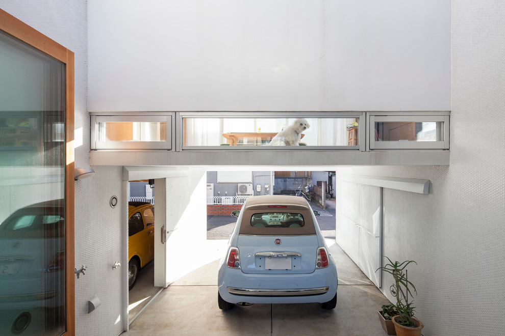 На фото: пристроенный гараж в современном стиле с навесом для автомобилей для двух машин
