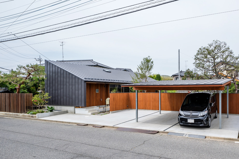На фото: отдельно стоящий гараж в скандинавском стиле с навесом для автомобилей