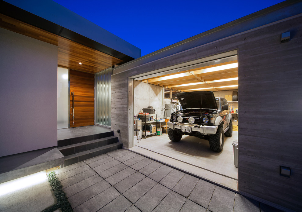 На фото: пристроенный гараж среднего размера в стиле лофт для одной машины