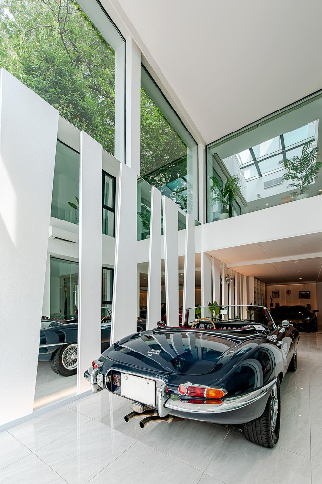 Exemple d'un garage pour quatre voitures ou plus attenant moderne avec une porte cochère.