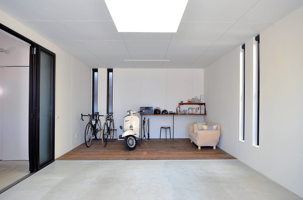Foto på en mellanstor minimalistisk tillbyggd garage och förråd, med entrétak