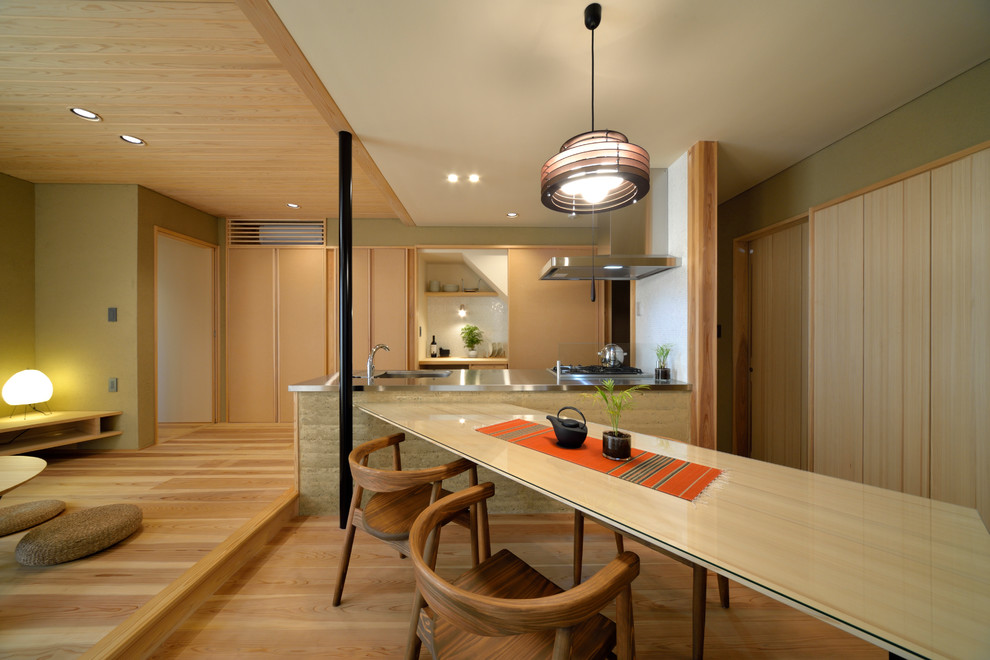 横浜にあるアジアンスタイルのおしゃれなキッチン (フラットパネル扉のキャビネット、中間色木目調キャビネット、ステンレスカウンター、無垢フローリング、茶色い床) の写真