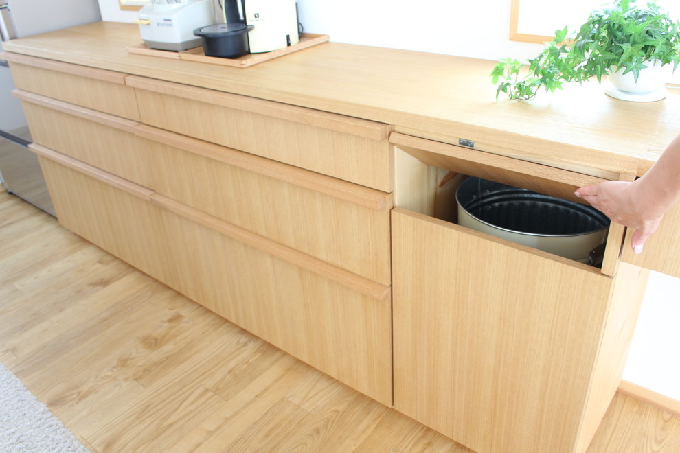 Esempio di una cucina scandinava di medie dimensioni con lavello sottopiano, ante in legno scuro, top in superficie solida, paraspruzzi bianco, paraspruzzi in gres porcellanato, elettrodomestici bianchi, pavimento in legno massello medio e nessuna isola