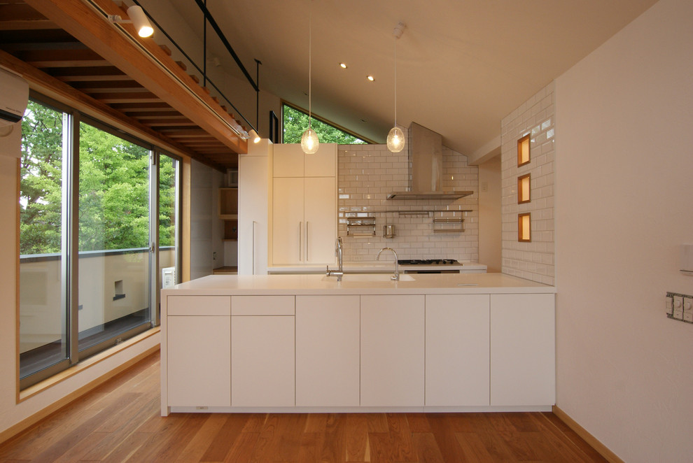 Пример оригинального дизайна: параллельная кухня-гостиная в скандинавском стиле с монолитной мойкой, плоскими фасадами, белыми фасадами, паркетным полом среднего тона, полуостровом, коричневым полом, белым фартуком, белой техникой и белой столешницей
