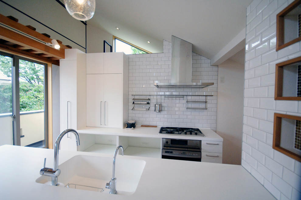 他の地域にある北欧スタイルのおしゃれなキッチン (一体型シンク、フラットパネル扉のキャビネット、白いキャビネット、白いキッチンパネル、白い調理設備、無垢フローリング、茶色い床) の写真