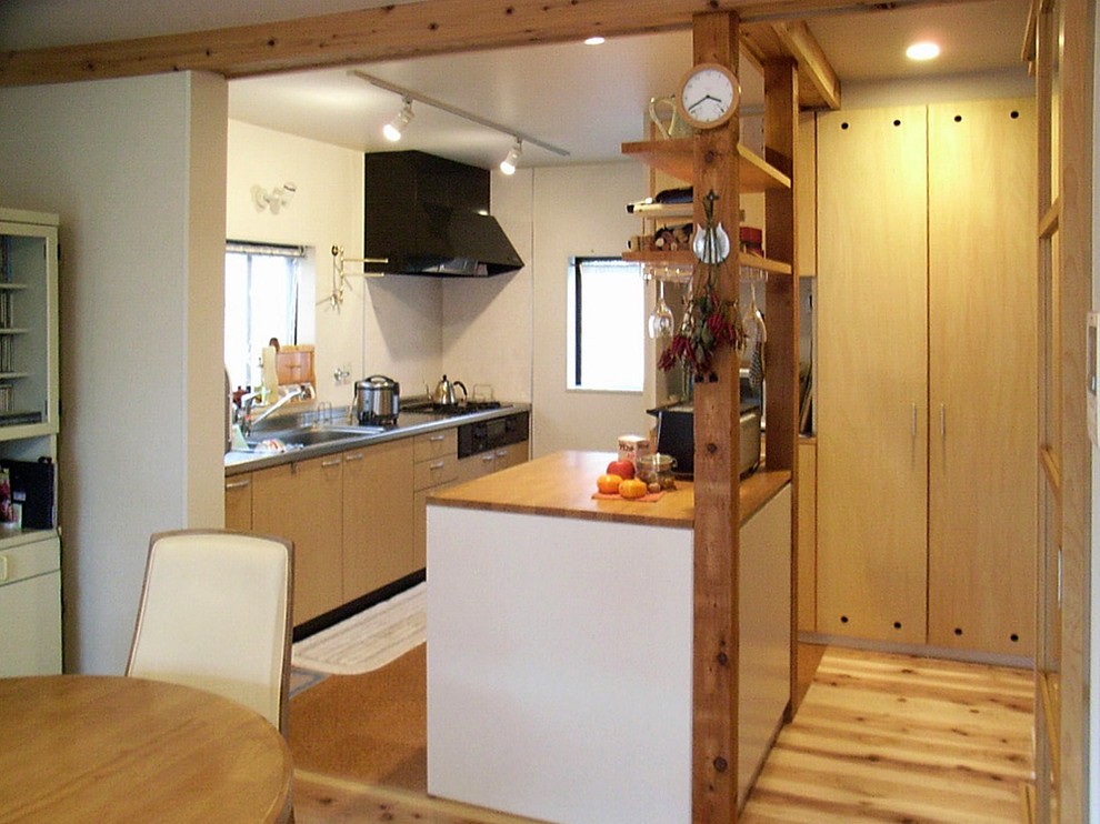 На фото: прямая кухня-гостиная в скандинавском стиле с плоскими фасадами, пробковым полом, островом и коричневым полом с