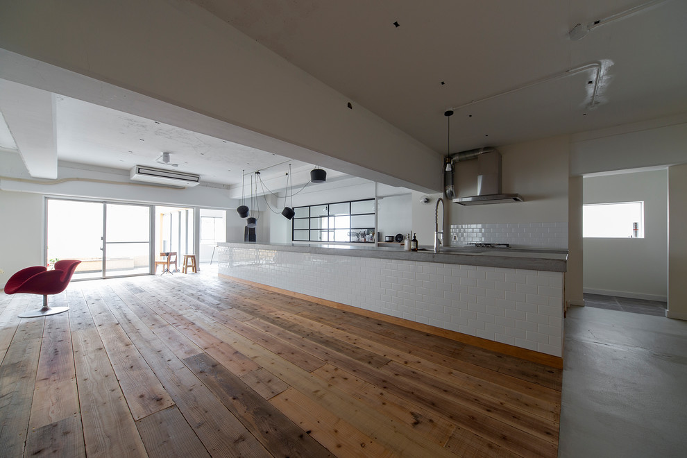 大阪にある広いインダストリアルスタイルのおしゃれなキッチン (アンダーカウンターシンク、インセット扉のキャビネット、コンクリートカウンター、白いキッチンパネル、サブウェイタイルのキッチンパネル、シルバーの調理設備、コンクリートの床、グレーの床) の写真