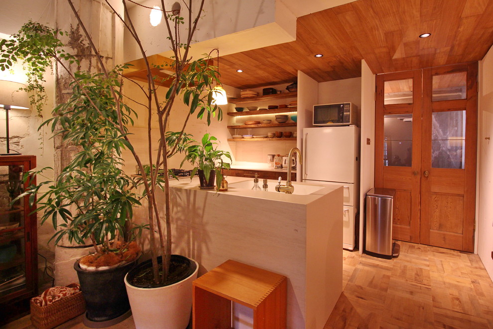 大阪にあるアジアンスタイルのおしゃれなキッチン (一体型シンク、茶色いキャビネット、白いキッチンパネル、無垢フローリング、茶色い床、白いキッチンカウンター) の写真