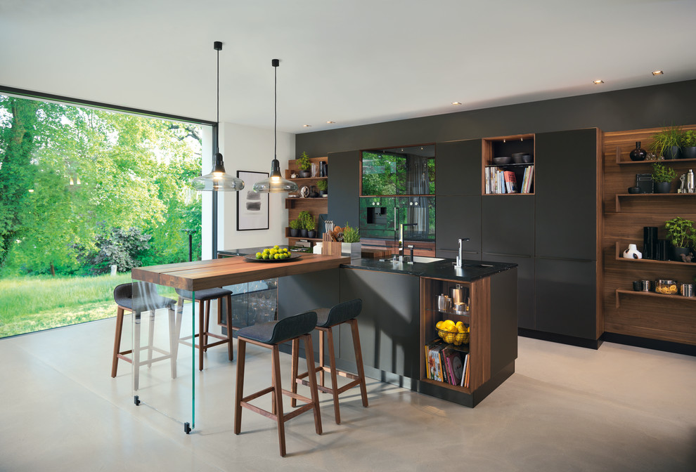 Einzeilige, Mittelgroße Moderne Wohnküche mit flächenbündigen Schrankfronten, schwarzen Schränken, Kücheninsel und grünem Boden in Sonstige