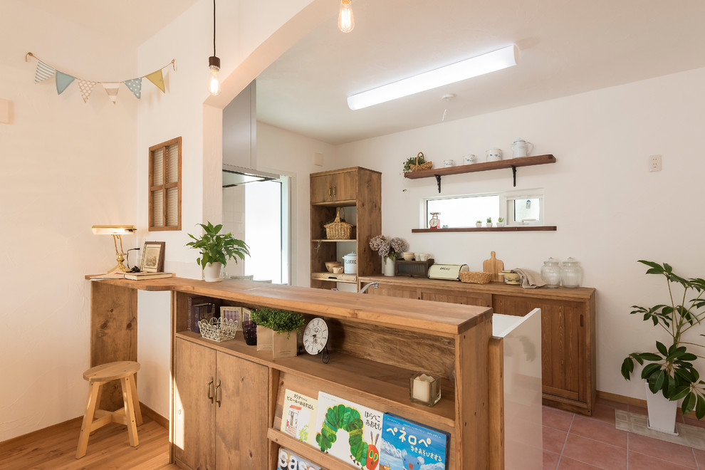 Photo of a rural galley open plan kitchen in Other with flat-panel cabinets, light wood cabinets, terracotta flooring and no island.
