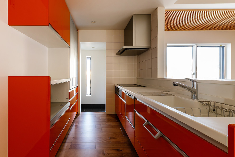 Idées déco pour une cuisine asiatique de taille moyenne avec des portes de placard rouges, plan de travail en marbre, une crédence rouge, une crédence en carreau de porcelaine et un plan de travail blanc.