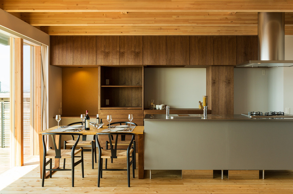 Modelo de cocina de estilo zen abierta con suelo de madera en tonos medios, suelo marrón, encimera de acero inoxidable y una isla