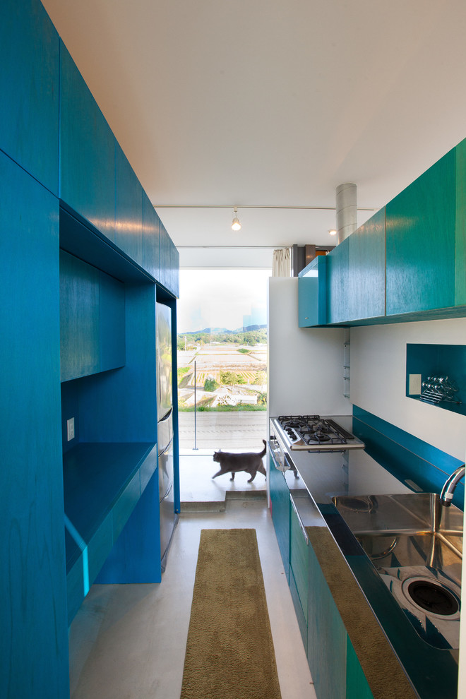 他の地域にあるコンテンポラリースタイルのおしゃれなキッチン (シングルシンク、フラットパネル扉のキャビネット、青いキャビネット) の写真