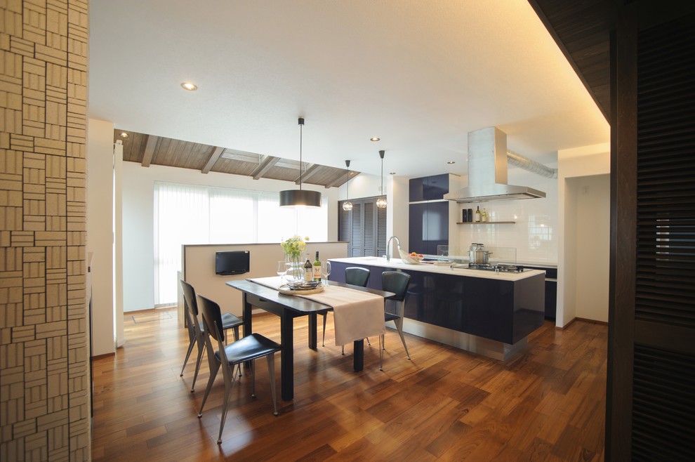 Zweizeilige Moderne Wohnküche mit Unterbauwaschbecken, flächenbündigen Schrankfronten, blauen Schränken, Küchenrückwand in Weiß, Küchengeräten aus Edelstahl, braunem Holzboden und Kücheninsel in Nagoya