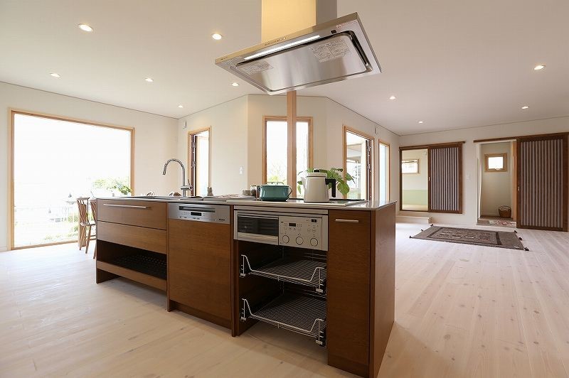 Cette photo montre une cuisine ouverte linéaire scandinave avec des portes de placard marrons, un plan de travail en inox, une crédence marron, une crédence en bois, un électroménager en acier inoxydable et parquet clair.