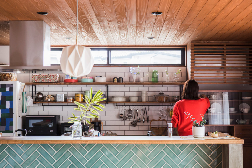 他の地域にあるアジアンスタイルのおしゃれなキッチン (木材カウンター、白いキッチンパネル、サブウェイタイルのキッチンパネル、板張り天井) の写真