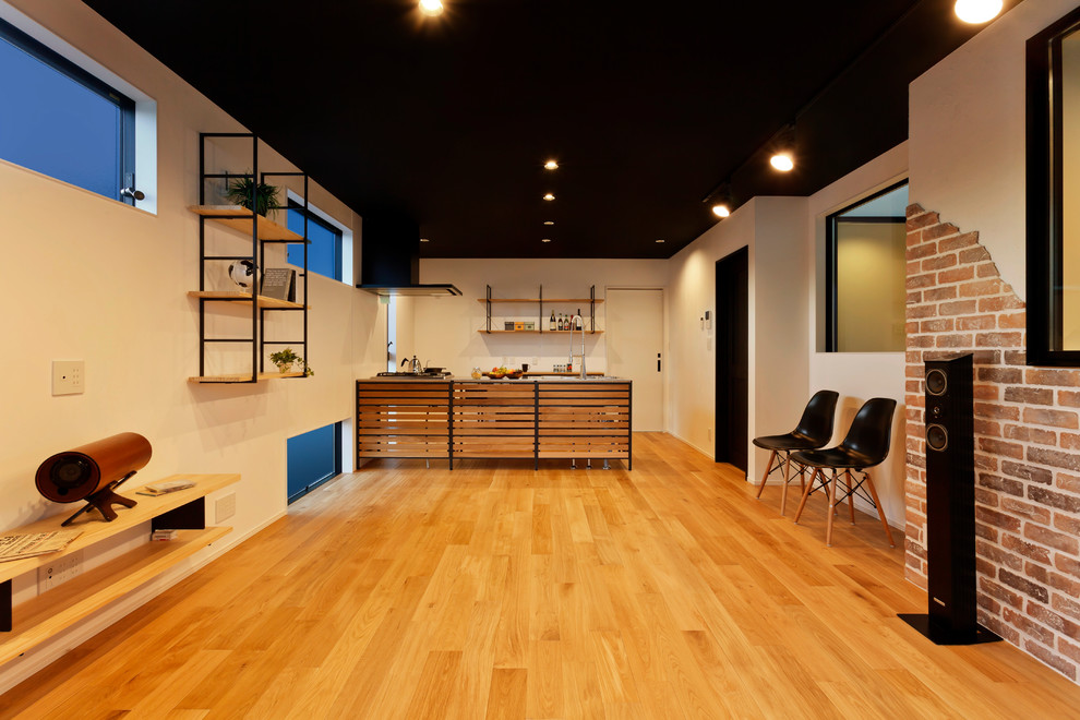 他の地域にあるインダストリアルスタイルのおしゃれなキッチン (無垢フローリング、茶色い床) の写真