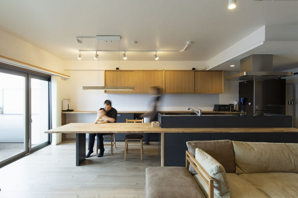 Foto di una cucina contemporanea con ante lisce, ante in legno chiaro, top in legno e parquet chiaro
