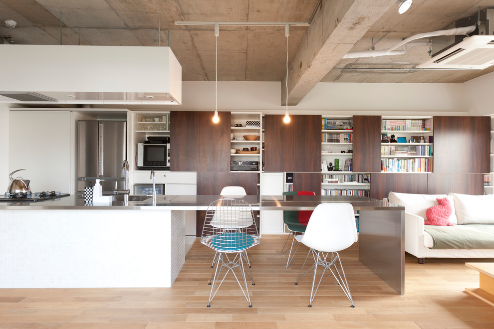 This is an example of a medium sized industrial single-wall open plan kitchen in Tokyo Suburbs with flat-panel cabinets, stainless steel appliances, stainless steel worktops, an integrated sink, white cabinets, white splashback, medium hardwood flooring and no island.
