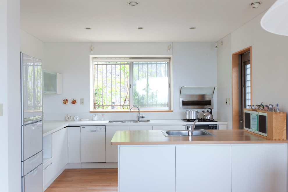 Exempel på ett mellanstort modernt kök, med en undermonterad diskho, luckor med glaspanel, vita skåp, träbänkskiva, vitt stänkskydd, stänkskydd i keramik, integrerade vitvaror, mellanmörkt trägolv och en halv köksö