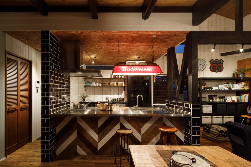 Immagine di una cucina stile marinaro con lavello integrato, top in acciaio inossidabile, pavimento in legno massello medio, penisola e pavimento marrone